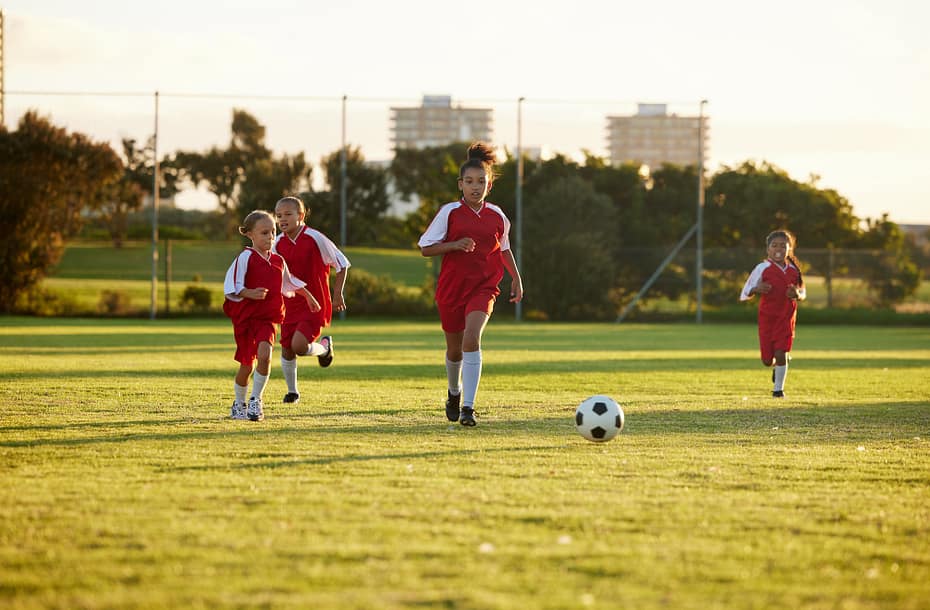 Sports, fitness and soccer training by girl team playing on grass field, teamwork during football g