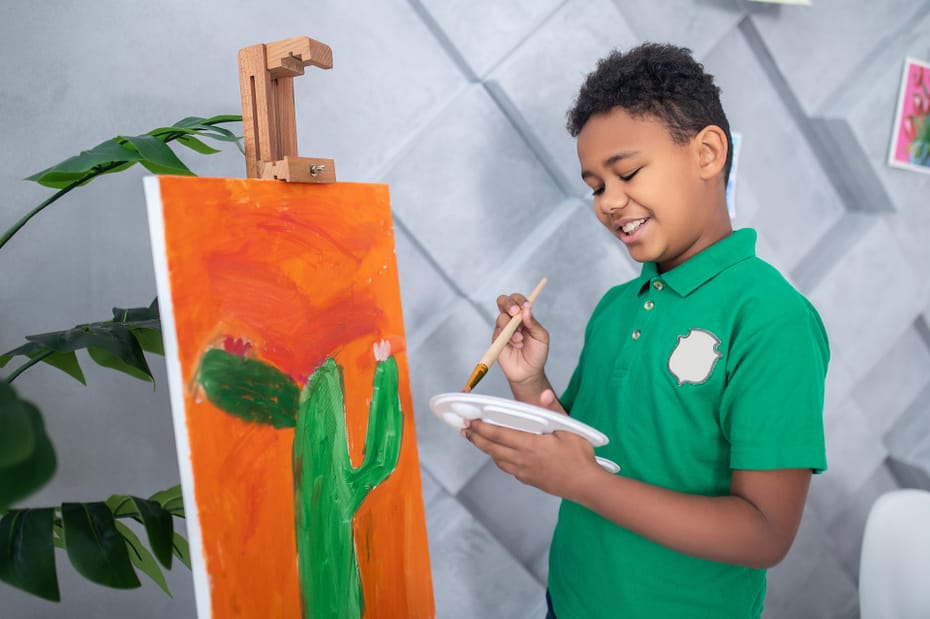 boy-with-palette-brush-standing-near-easel boy-with-palette-brush-standing-near-easel